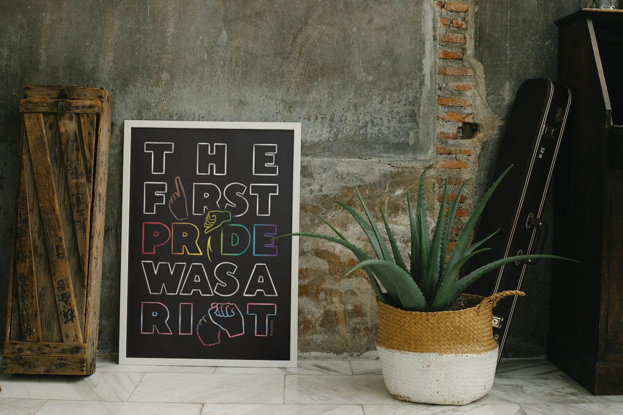 Poster mockup in a white frame beside a wooden case and an agave plant